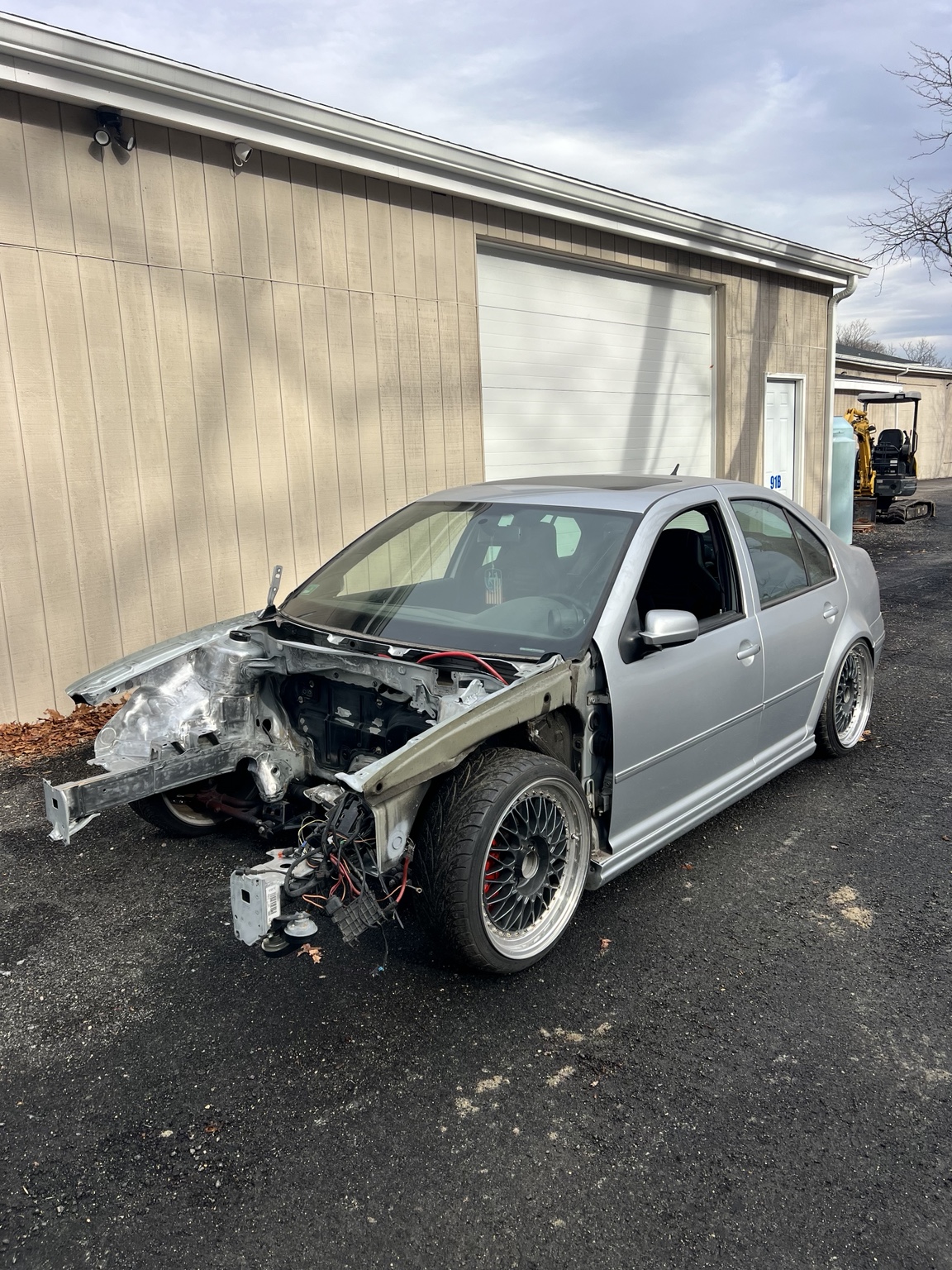 Silver vehicle with front end disassembled during engine bay work